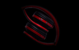 A red and black pair of headphones on a black background.